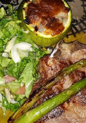 Una foto de Bifes Con Espárragos, Zapallitos Rellenos Y Ensalada
