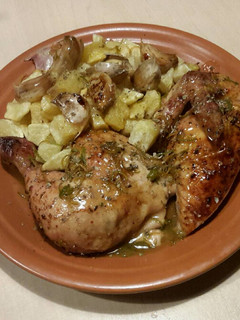 Una foto de Pollo asado con zumo de naranja y ajos