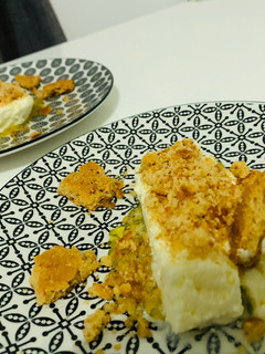 Una foto de Pastel de queso fresco con base de melocotón y crujiente de frutos secos