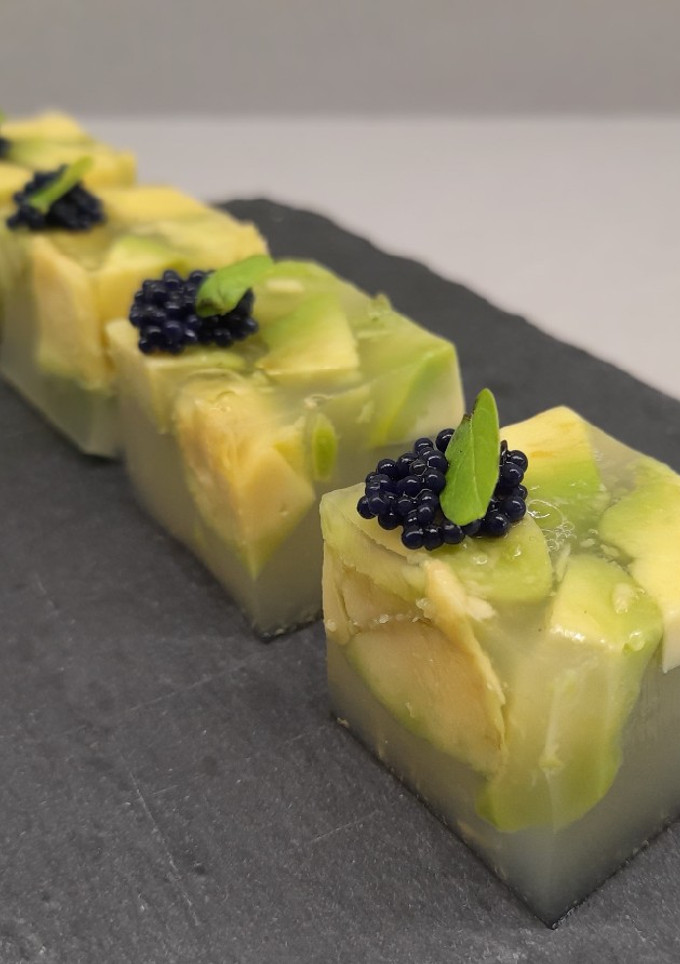 Una foto de Cubos de aguacate con pepino y lima, huevas y hojita albahaca