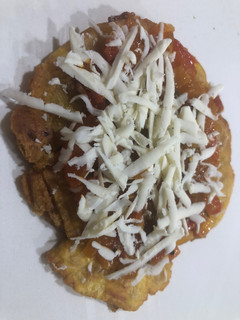 Una foto de Patacones con hogao y queso costeño rallado