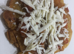 Una foto de Patacones con hogao y queso costeño rallado