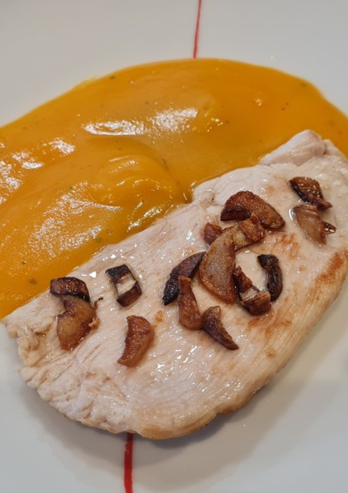 Una foto de Pechuga de pavo al ajillo con puré de patata y zanahoria