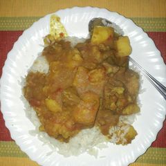 A picture of Rice with beef stew mixed with potatoes.