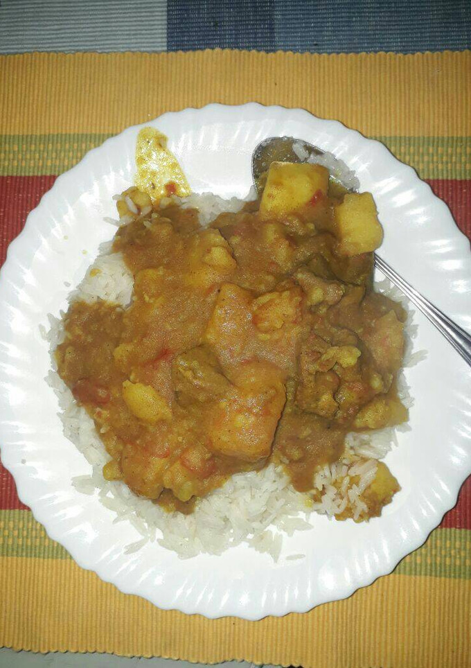 A picture of Rice with beef stew mixed with potatoes.