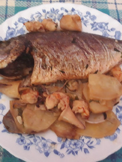 Una foto de Dorada al horno con almejas, gambón, patatas y chipirones