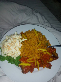 A picture of Jollof rice,coleslaw and fried irish potatoes.