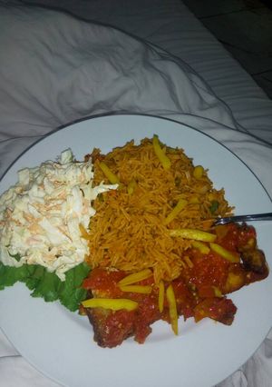 A picture of Jollof rice,coleslaw and fried irish potatoes.