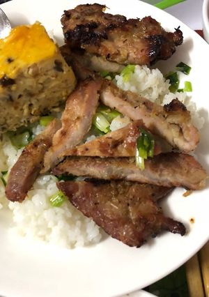 A picture of Vietnamese Broken Rice with Grilled Pork Chop and Egg Meatloaf (Cơm tấm sườn chả trứng).