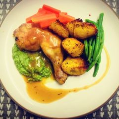 A picture of Roasted Chicken Leg with Pea Puree and Turmeric Potatoes.
