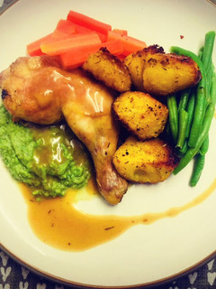 A picture of Roasted Chicken Leg with Pea Puree and Turmeric Potatoes.