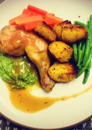 A picture of Roasted Chicken Leg with Pea Puree and Turmeric Potatoes.