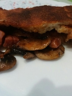 Una foto de Calzone con jamón, mozzarella y champiñones