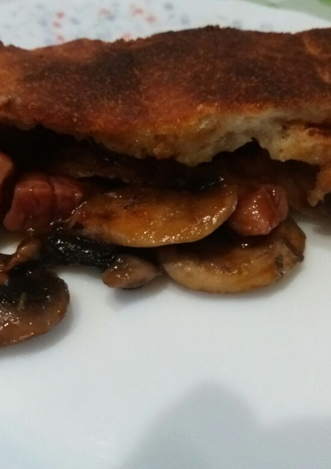 Una foto de Calzone con jamón, mozzarella y champiñones