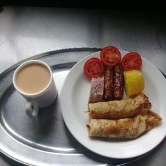 A picture of Orange pancakes, beef sausages, Arrowroots, sweetpotatoes, tea.