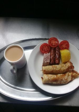 A picture of Orange pancakes, beef sausages, Arrowroots, sweetpotatoes, tea.