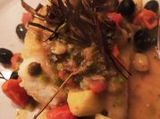 Una foto di baccalà con capperi