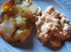 Una foto de Pollo con salsa de queso y papas doradas