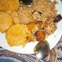A picture of Jollof Rice with Moi-moi and fried plantain.