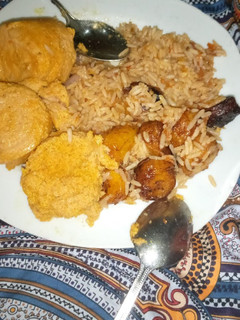 A picture of Jollof Rice with Moi-moi and fried plantain.