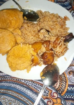A picture of Jollof Rice with Moi-moi and fried plantain.