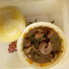 A picture of White soup with yellow garri.