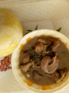A picture of White soup with yellow garri.