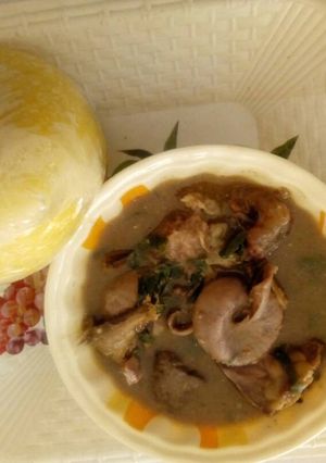 A picture of White soup with yellow garri.