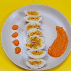 A picture of Stuffed idli with tomato chutney.