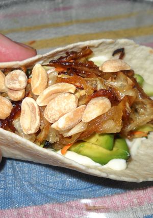 Una foto de Tacos con pollo, palta, cebolla dorada y maní