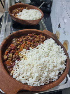 A picture of Beans and rice sizzler in a clay pan.