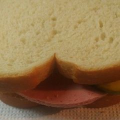 A picture of Bologna Sandwich with homemade Bread and butter pickles.