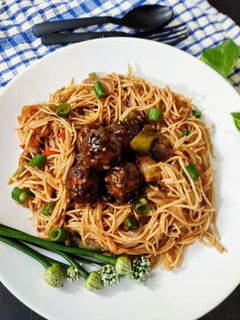 A picture of Veg noodles with manchurian.