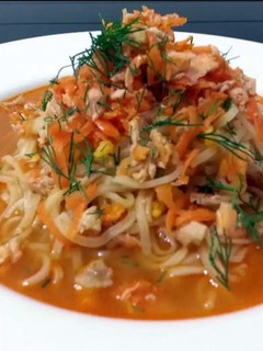 A picture of Salmon And Spiced Carrot On Ramen Noodle Soup.