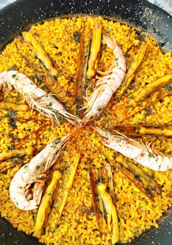 Una foto de Arroz con navajas y gambones