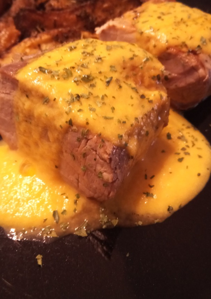 Una foto de Solomillo de Cerdo a Baja Temperatura con Salsa de Naranja, Puerro y Zanahoria con Patatas Gajo