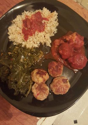 A picture of Cajun chicken meatballs with kale & collard green a brown rice.