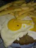 Milanesas de res a caballo con papas fritas
