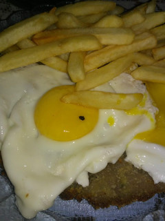 Una foto de Milanesas de res a caballo con papas fritas