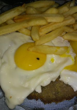 Una foto de Milanesas de res a caballo con papas fritas