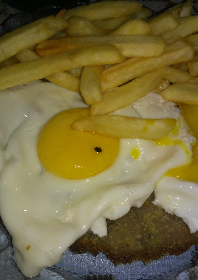 Una foto de Milanesas de res a caballo con papas fritas