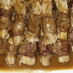 A picture of Enoki mushrooms beef rolls with satay sauce.