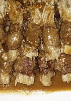 A picture of Enoki mushrooms beef rolls with satay sauce.