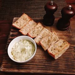 A picture of Toasted onion poppy ciabatta bread with goat cheese and pesto.