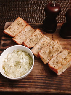 A picture of Toasted onion poppy ciabatta bread with goat cheese and pesto.