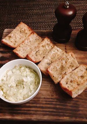 A picture of Toasted onion poppy ciabatta bread with goat cheese and pesto.