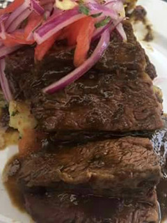 Una foto de Carne en salsa de vino blanco sobre puré rústico