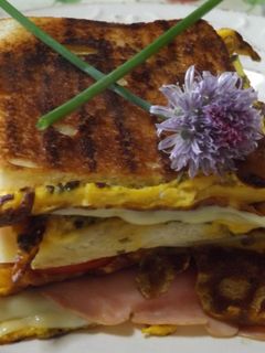 Una foto de Sándwich triple calentito con tortilla de cebollinos