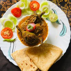 A picture of Bharela Ringana (Stuffed Brinjals) with chapati in lunch.