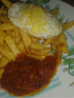 A picture of Chips and egg with sauce.